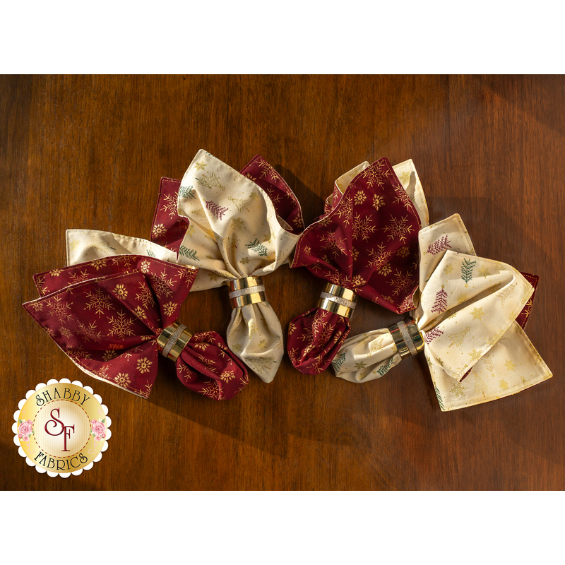 Four cloth napkins in napkin rings arranged in a fan on a wooden table