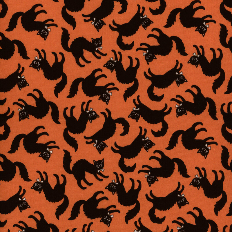 Orange fabric featuring bowtie wearing black cats with arched backs tossed all over