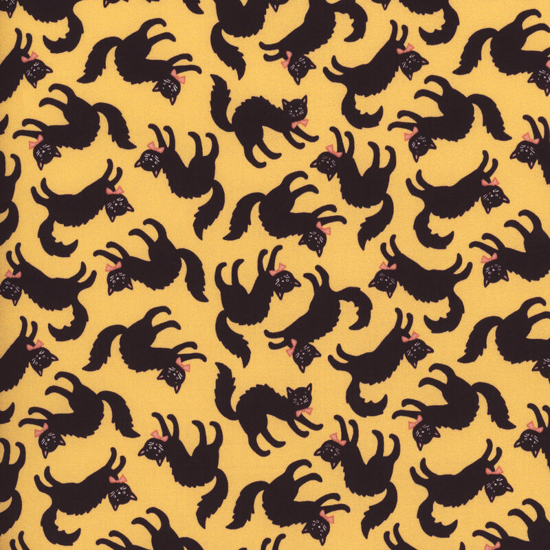 Yellow fabric featuring bowtie wearing black cats with arched backs tossed all over