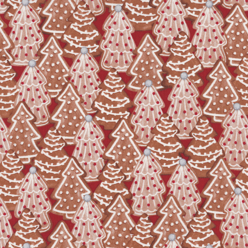fabric featuring decorated Christmas tree cookies on a red background