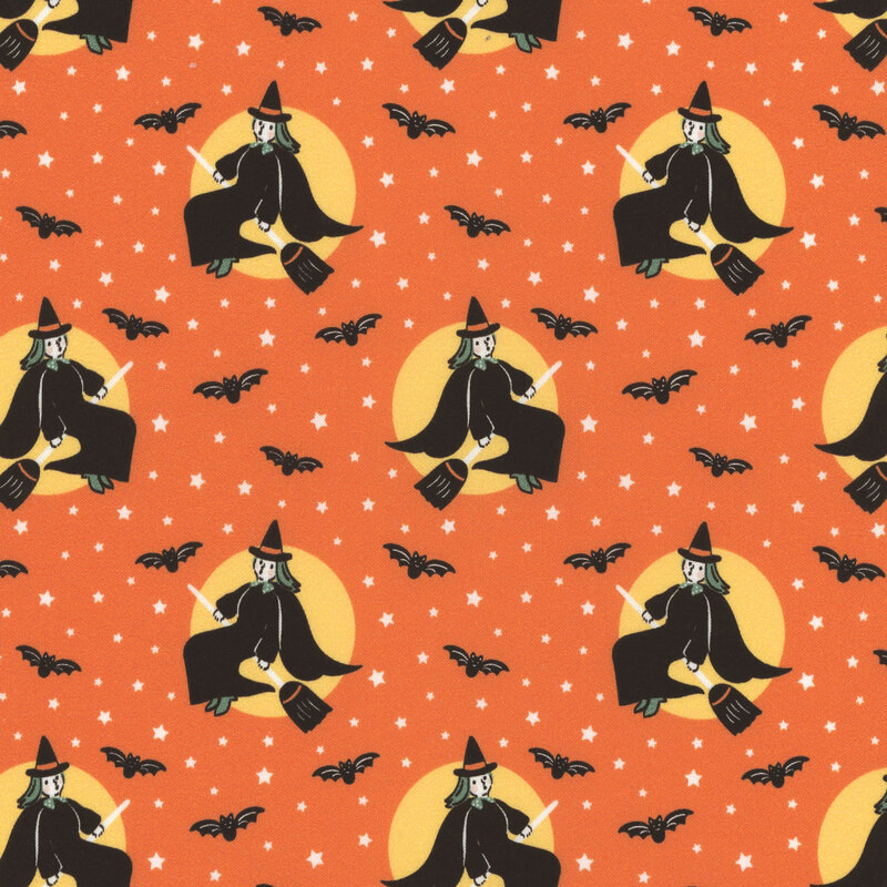Orange fabric featuring white stars and black bats tossed amid images of a vintage style witch riding a broomstick in front of a yellow moon.
