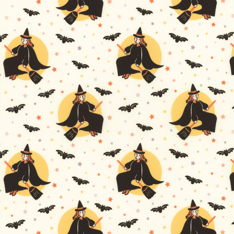 Natural cream fabric featuring colorful stars and black bats tossed amid images of a vintage style witch riding a broomstick in front of a yellow moon.