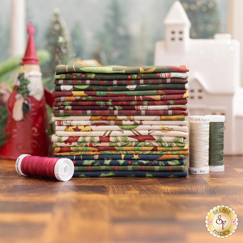 An Up On The Housetop 21 Fat Quarter Bundle surrounded by christmas decor.