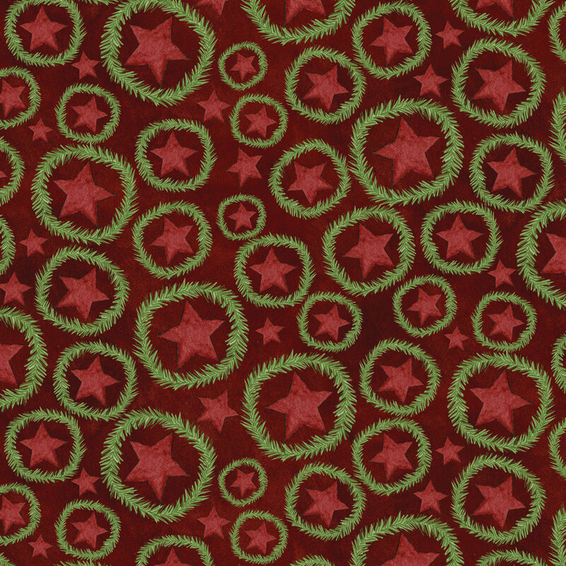 rich cranberry red fabric featuring scattered red stars with fir wreaths surrounding them