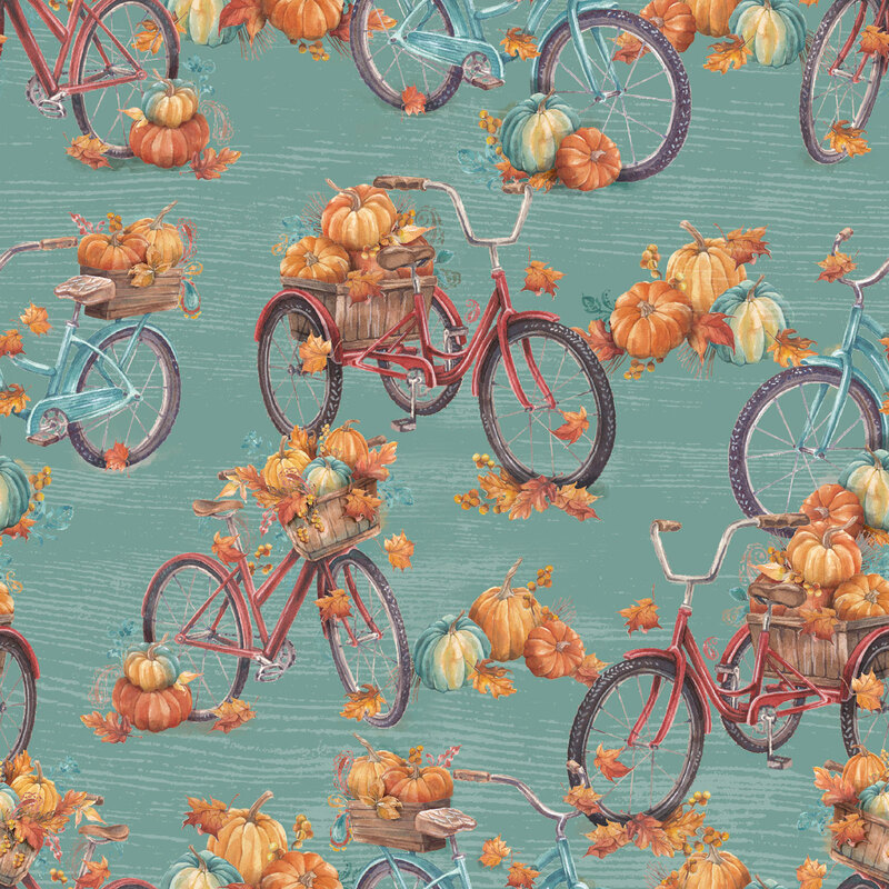 Teal fabric with red an blue bikes with piles of pumpkins in the baskets.
