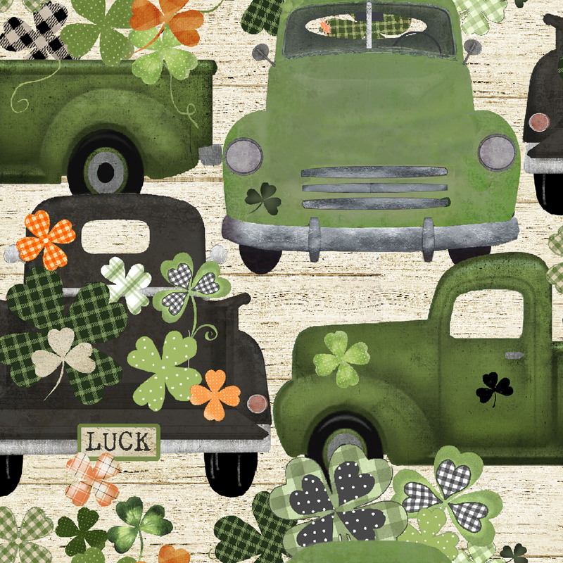 fabric featuring green trucks and four leaf clovers on a cream wooden textured background