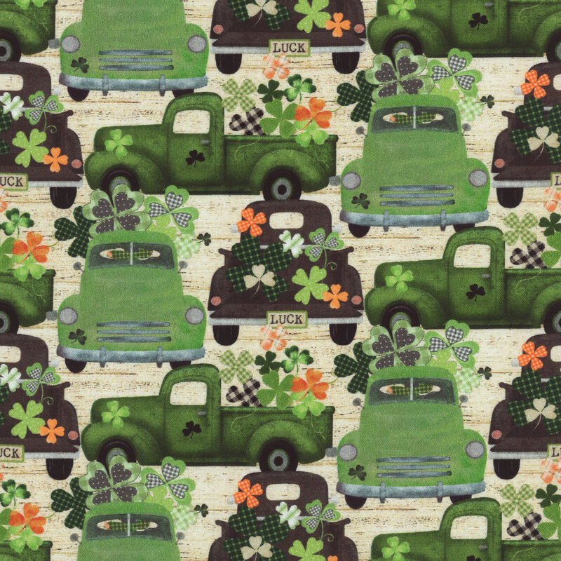 fabric featuring green trucks and four leaf clovers on a cream wooden textured background