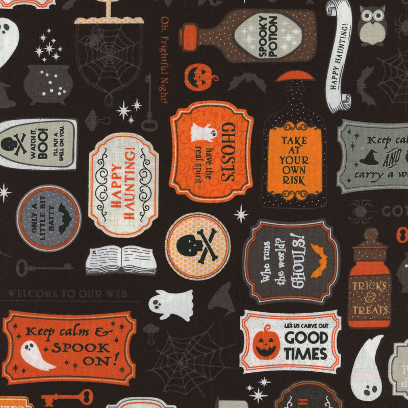 Black fabric featuring spooky potions, signs, webs, and other halloween themed elements