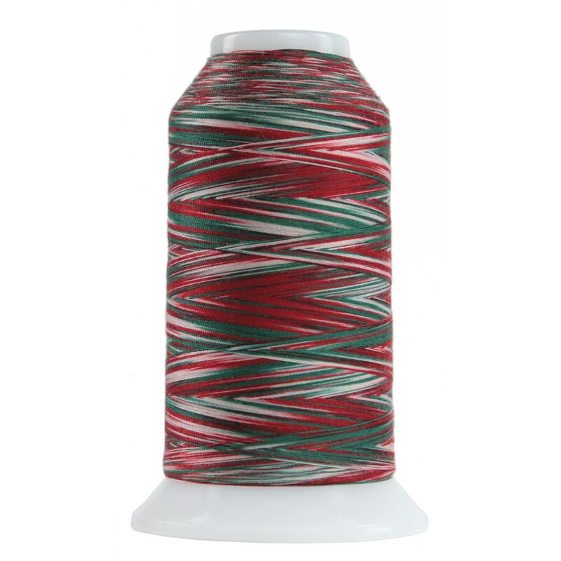 Large spool of variegated red, white, and green thread isolated on a white background