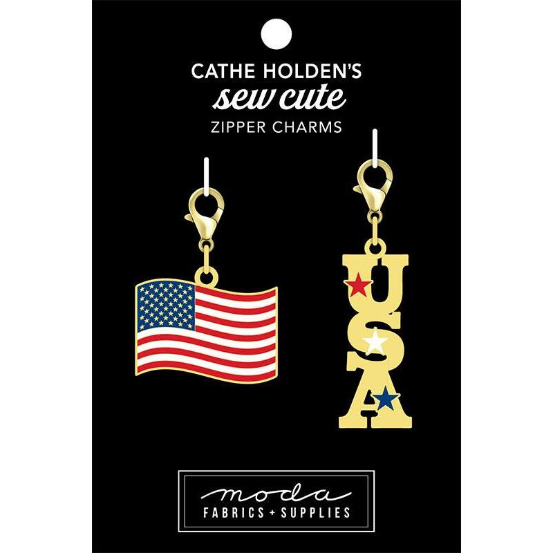 Image of a black tag with two charms, an american flag and the letters USA with stars