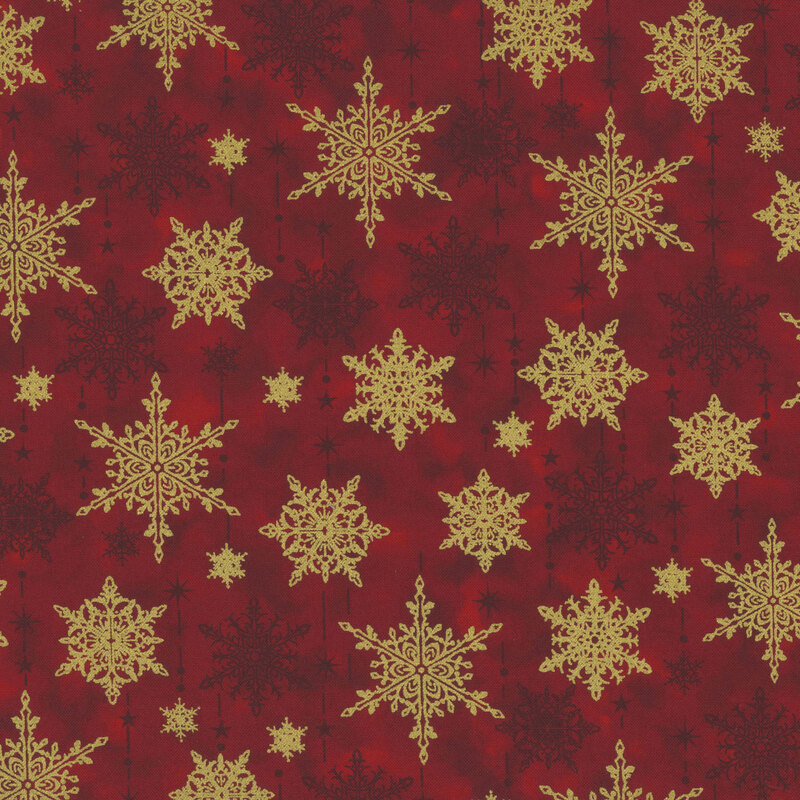 gorgeous red mottled fabric with scattered tonal and metallic gold snowflakes with tonal dots, stars, and dashes mimicking the falling of snow
