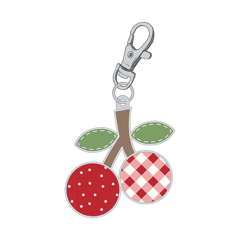 Enamel pin with a clip: one cherry that is red with white polka dots, and one cherry with a red and white gingham print.