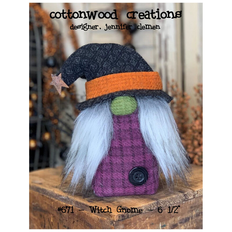 Front cover of the pattern, showing the completed witch gnome staged on a rustic wood block with autumn foliage in the background