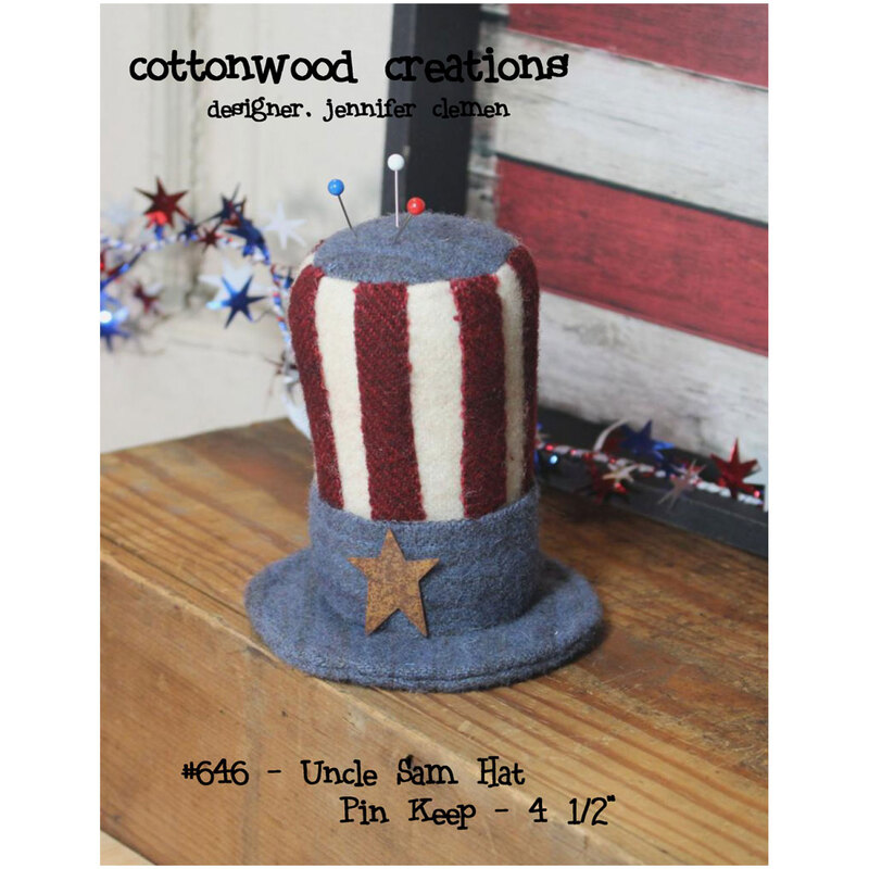 Front of the pattern showing the completed Uncle Sam Hat pin keep staged on a table top with wood painted red and white in the background.