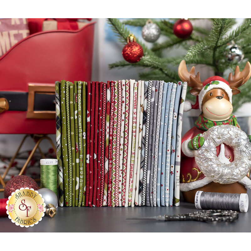 On Dasher fabrics in muted shades of icy blue, white, red, and green on a grey table with a reindeer and sleigh