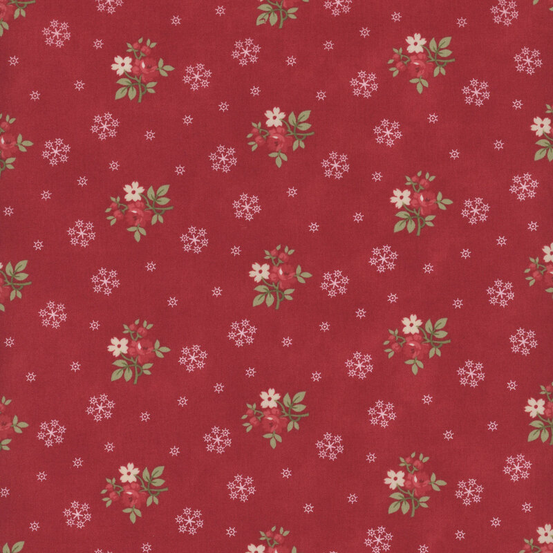 This red fabric features bunches of red and cream flowers with white snowflakes all evenly spaced apart