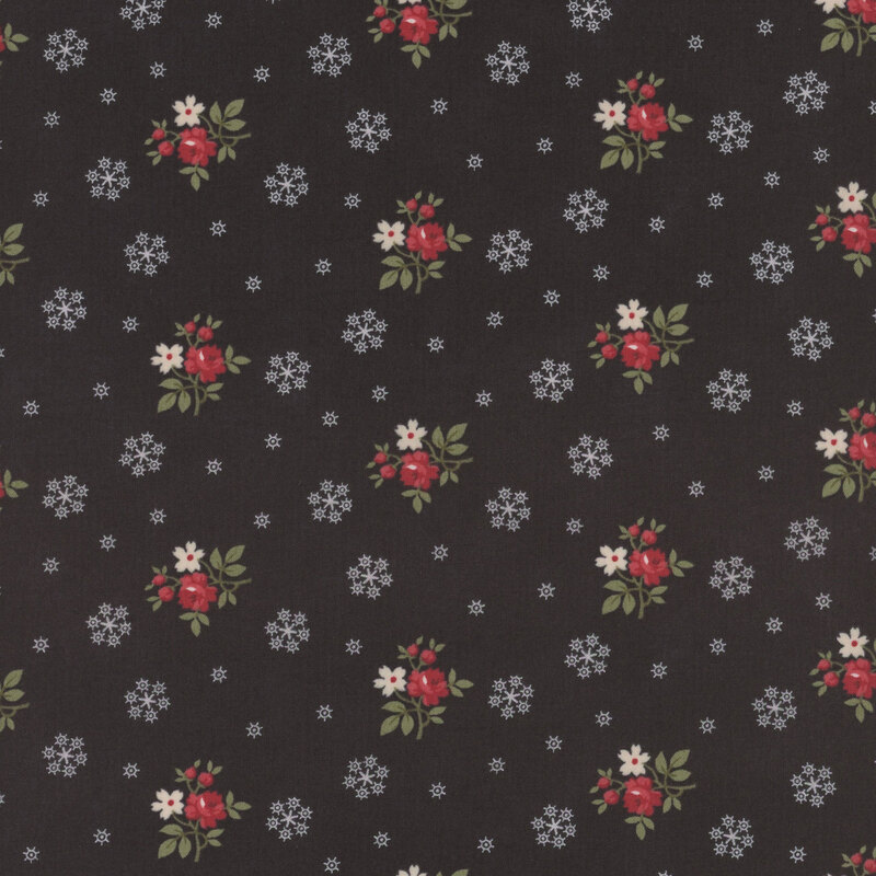 This black fabric features bunches of red and cream flowers with white snowflakes all evenly spaced apart