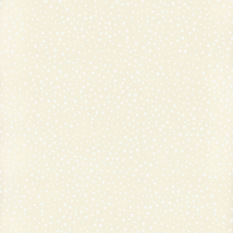 White dots ranging in size and scattered across cream fabric.