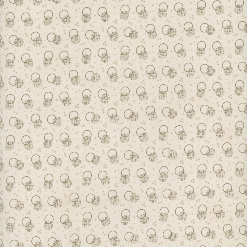 cream fabric with light tan speckling and layered warm taupe circles and stippled polka dots