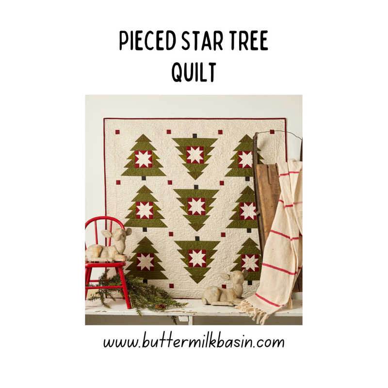 Cover of the pattern showing the completed quilt hung above a work table, staged with a rustic sled, chair, pine boughs, and little wooden lambs.