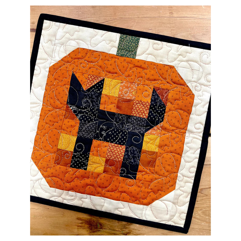 Cover photo for the pattern, showing the completed project in orange, cream, and black, at a slight angle, showing stitching details.