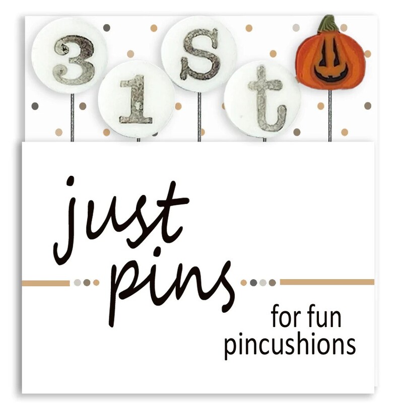 A digital mockup of the packaging for the pins, showing a smiling orange jack 'o' lantern and four pins that spell out 