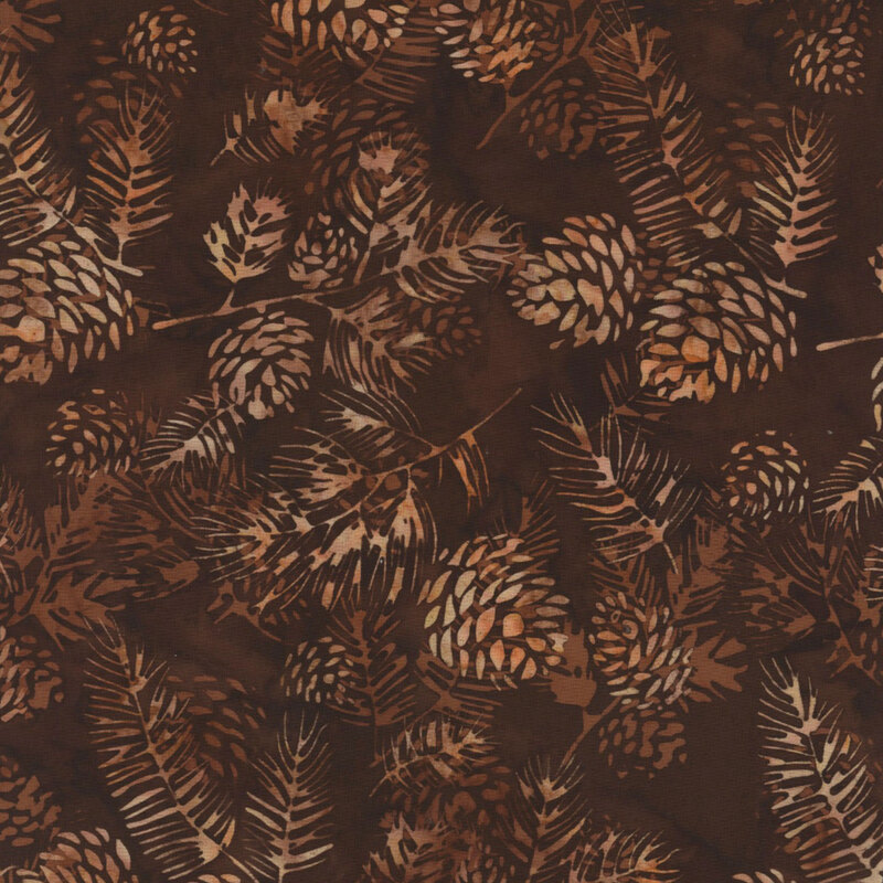 lovely brown mottled batik fabric featuring scattered brown and tan mottled pinecones and fir needle branches