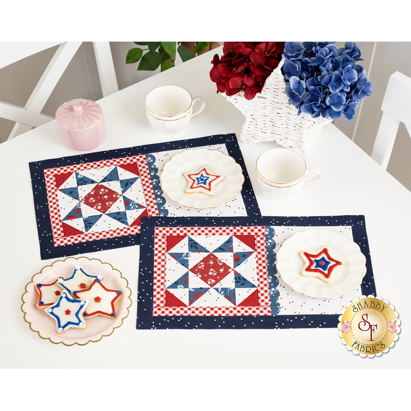 The completed July placemats in a patriotic palette of red, white, and blue, staged on a white table with coordinating teaware and decor.