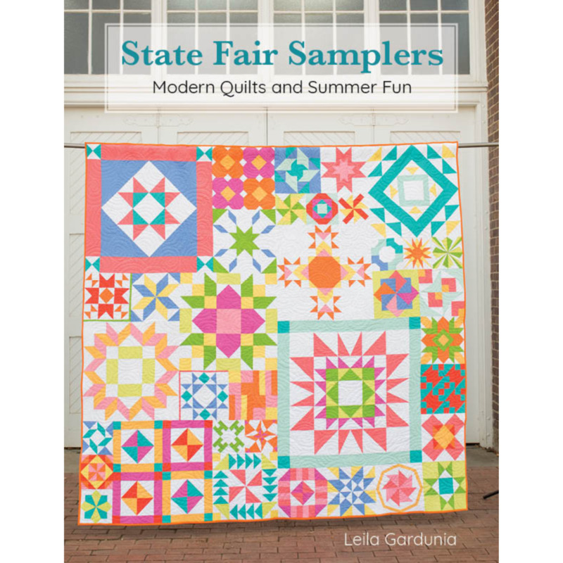 Front cover of the pattern featuring a colorful sampler quilt, staged in front of white panel doors.