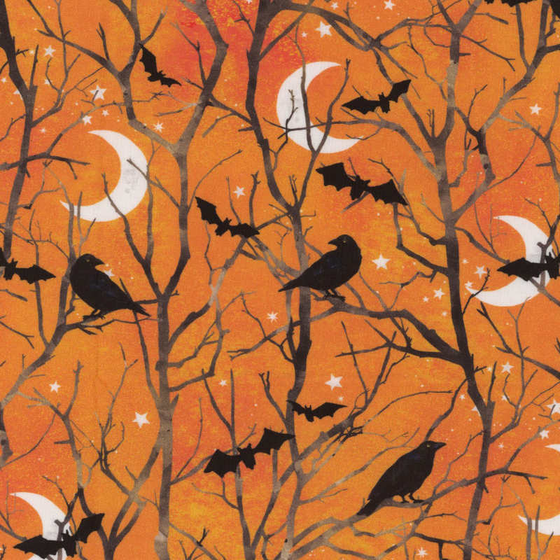 Mottled orange fabric with bare tree branches with little black bats, crows, crescent moons, and stars.