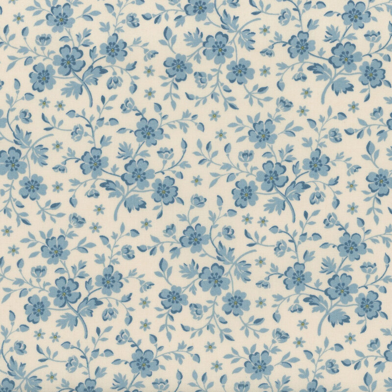 Cream-colored fabric with light blue flowers and leaves with yellow accents.