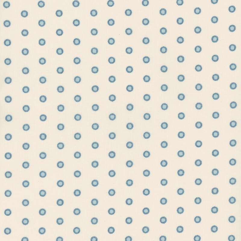 Cream fabric swatch with two-tone blue polka dots.