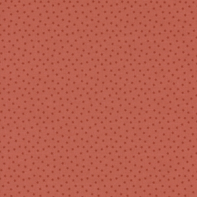 Salmon pink fabric with a pattern of tiny stars in a row