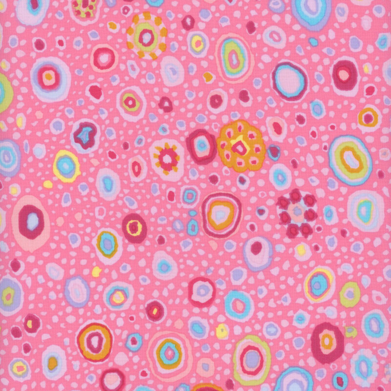 Pink fabric featuring multicolor dots in various sizes and color combinations.
