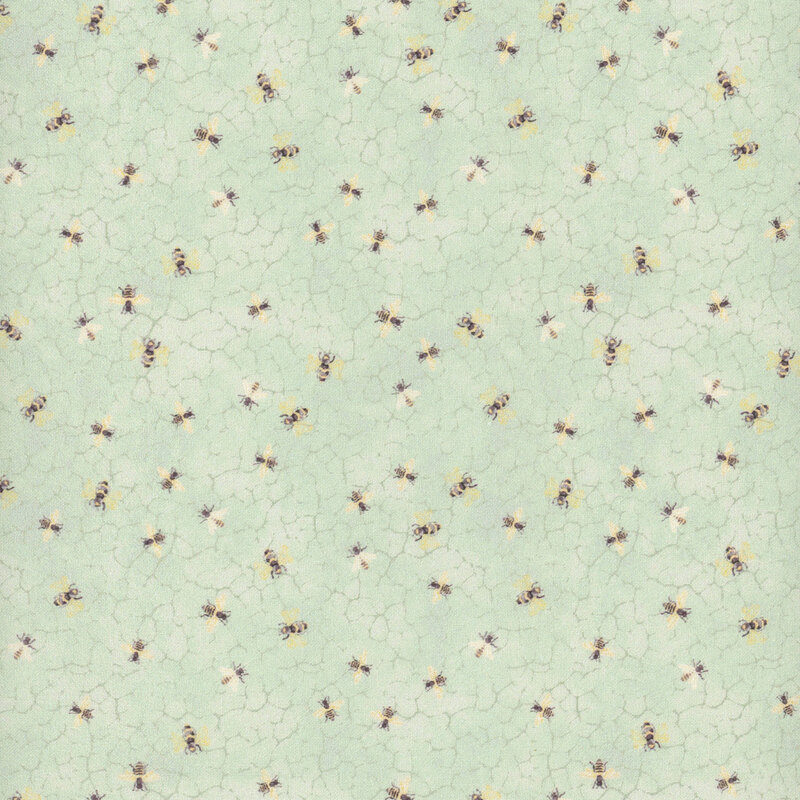 Fabric with bees on a pastel green honeycomb textured background