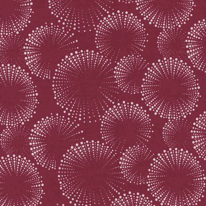 Deep burgundy fabric with dotted fireworks in white.