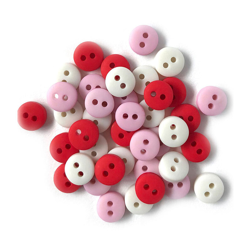 Pile of red pink, and white buttons against a white background