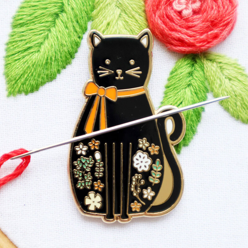 The black cat needle miner displayed on a hand embroidery project 