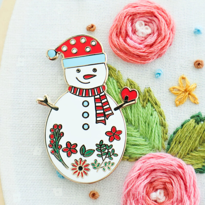 The snowman needle miner displayed on a hand embroidery project 