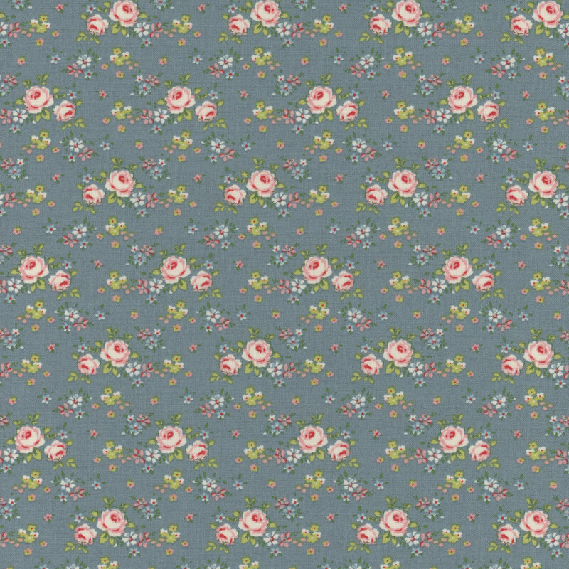 Blue fabric with clusters of pink roses and small blue flowers with green leaves