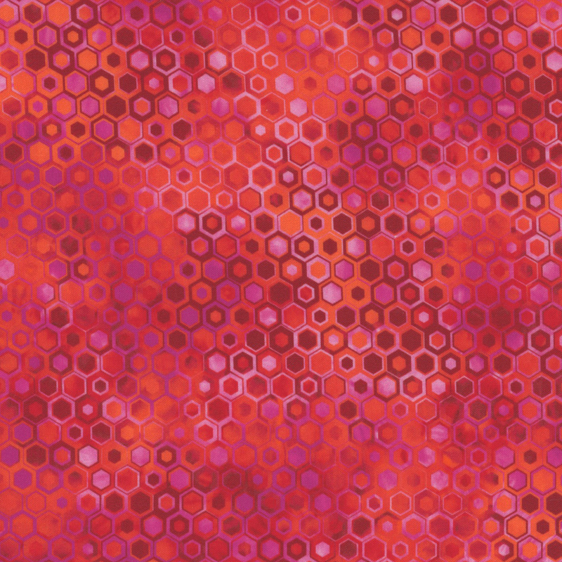 beautifully mottled geometric fabric featuring a honeycomb pattern filled with nestled hexagons in varied shades of vibrant red, pink, and fuchsia
