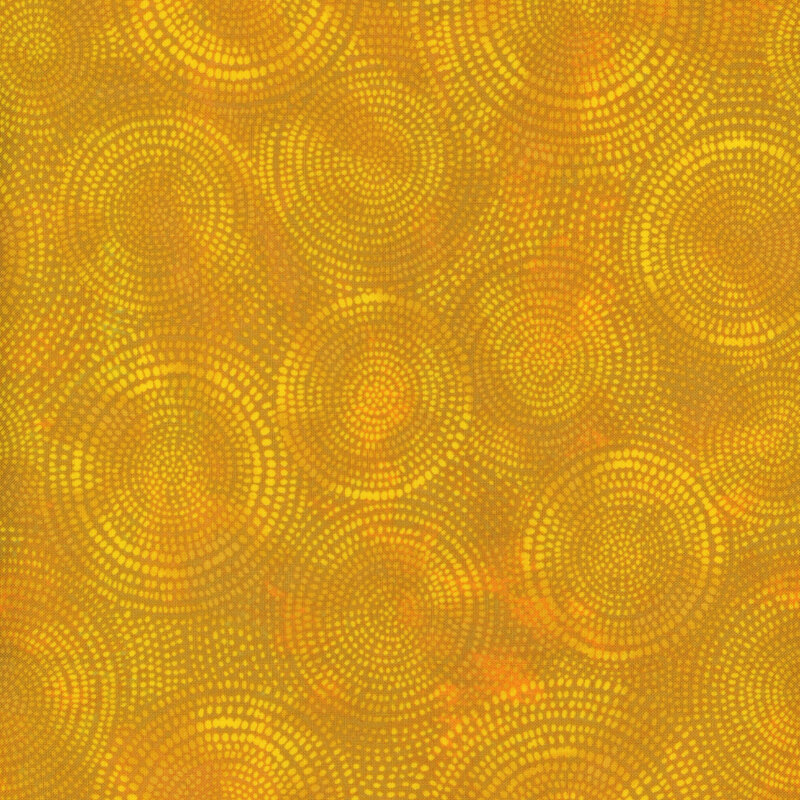 Photo of dusty yellow mottled fabric with pale tonal rings made up of tiny dashes