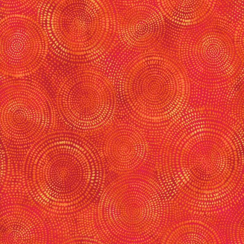 Photo of bright orange and yellow mottled fabric with pale tonal rings made up of tiny dashes