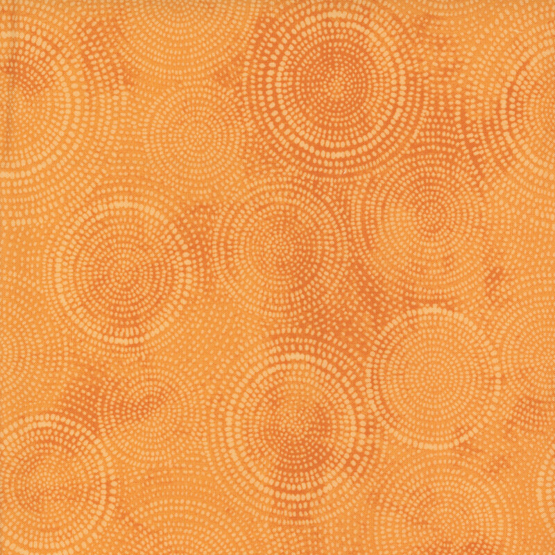 Photo of light orange mottled fabric with pale tonal rings made up of tiny dashes