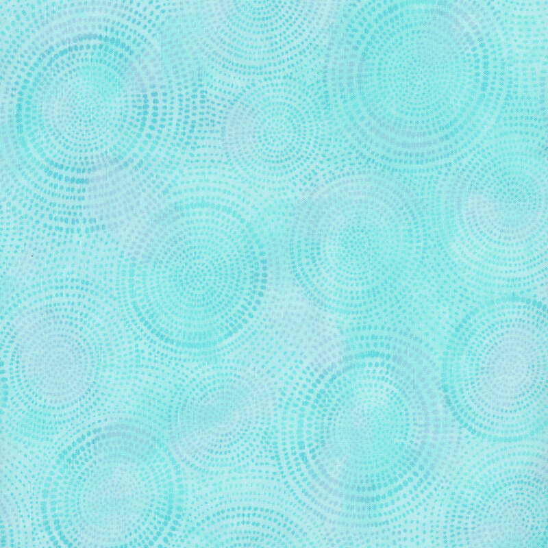 Photo of light blue mottled fabric with darker tonal rings made up of tiny dashes