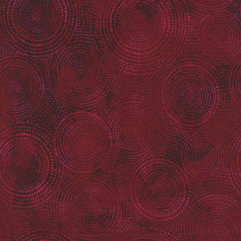 Photo of dark red mottled fabric with lighter tonal rings made up of tiny dashes