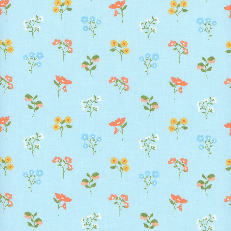 Blue fabric with a pattern of floral sprigs in pink, blue, and yellow.