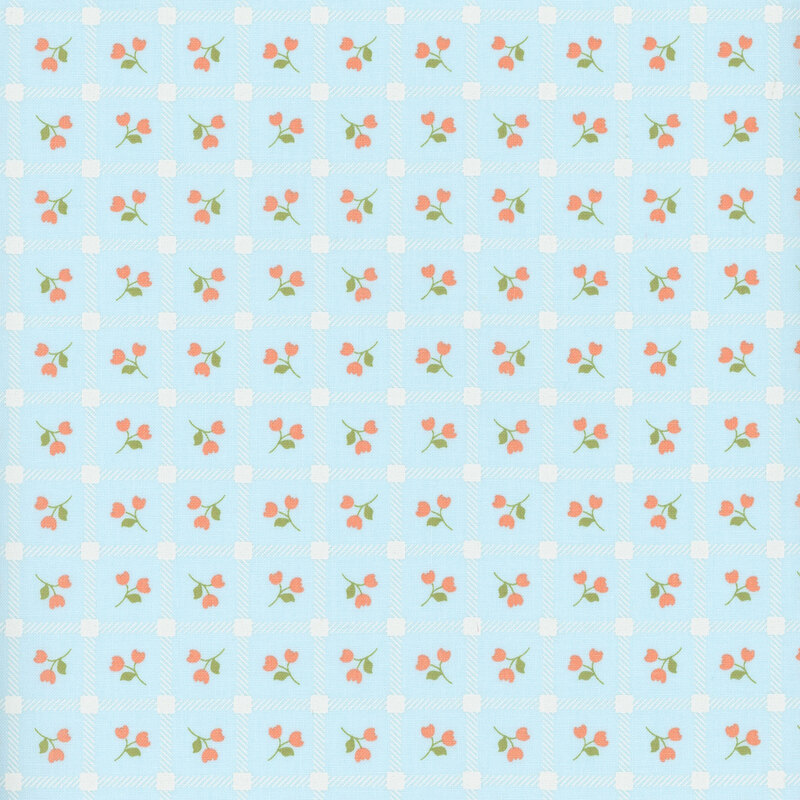 Blue fabric with a pattern of pink floral sprigs in a white grid.