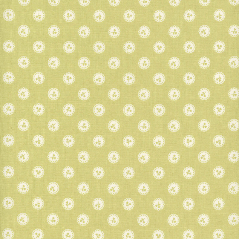 Green fabric with a pattern of green floral sprigs in white buttons.