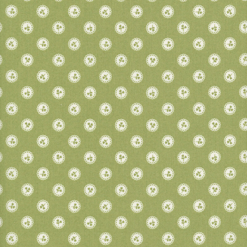 Green fabric with a pattern of green floral sprigs in white buttons.